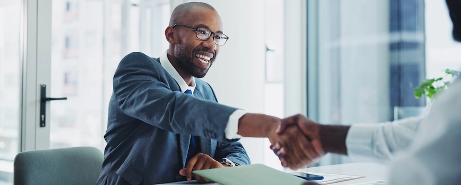 A rideshare accident lawyer is shaking hands with a client.